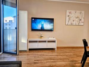 Una sala de estar con un televisor en la pared. en Ana Residence, en Timisoara