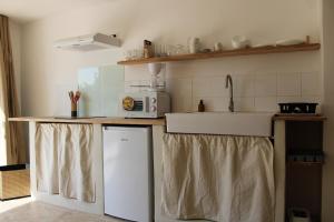 a kitchen with a counter with a sink and a microwave at Le Laoul cottage 2 people in Bourg-Saint-Andéol