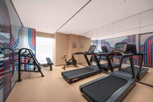 a gym with several tread machines in a room at Holiday Inn Express Rizhao Oriental Colorful City in Rizhao +56 photos