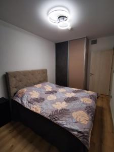 a bedroom with a bed with a floral bedspread at Cevahir Sky View in Skopje