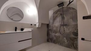 a bathroom with a shower with a mirror and a sink at VIALI Guest House in Fasano