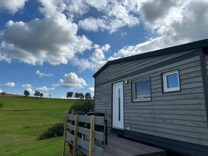 a tiny house with a wooden ramp next to a field at Tiny House auf dem Lande in Hilders