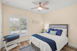 a bedroom with a bed with blue pillows and a ceiling fan at Datura Dreams in Southgate