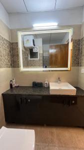 a bathroom with a sink and a mirror at Isha Homes in Greater Noida