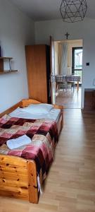 a bedroom with a wooden bed and a dining room at Noclegi u Lili in Człuchów