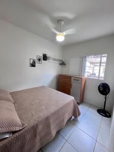 a bedroom with a bed and a ceiling fan at home select apto inteiro 2 quartos Araguari in Araguari +5 photos