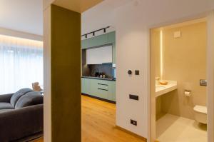 ein Wohnzimmer mit Sofa und eine Küche in der Unterkunft Cuza 16 - Central Premium Apartments in Braşov + 86 Fotos