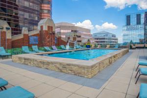 a swimming pool with chairs and a building at 2B 2BA Luxury Downtown Suite Rooftop Deck & Gym in Baltimore