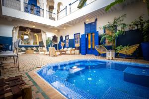a swimming pool in a large room with a house at Riad Sheba in Marrakech