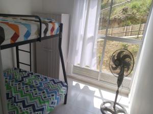 a bedroom with a bunk bed next to a window at Apartamento en melgar tolima in Melgar
