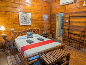 a bedroom with a bed in a room with wooden walls at Choona Lodge 'view of sigiriya & pidurangala with sunrise' in Sigiriya
