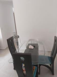 a glass table with a chair and a desk with a fan at Apartamento en melgar tolima in Melgar +10 photos
