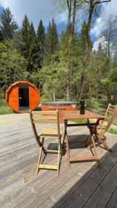 un tavolo da picnic e sedie su un ponte con una tenda di Glamping Všímarský Stream a Malšín