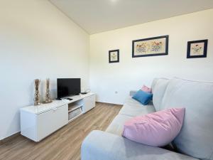 a living room with a couch and a tv at Suites de Braga in Braga