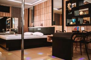 a bedroom with a bed and a table and a chair at Romanus Piracicaba in Piracicaba