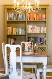 a dining room with a table and a book shelf with books at Chambery in Cape Town