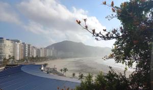 een uitzicht op een strand met gebouwen en een berg bij Apto Vista Mar com Ar cond, Piscina, Wifi, TV e Garagem 2 vagas in São Vicente