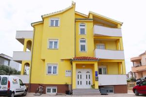 a yellow house with a white door at Apartments Bella in Vodice