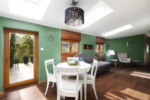 a living room with a table and chairs and a couch at Aparthotel Miodowa 25 in Kraków