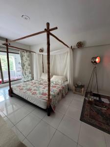 a bedroom with a bed with a wooden canopy at Alchemist Abode - Country Club Apartments in Islamabad