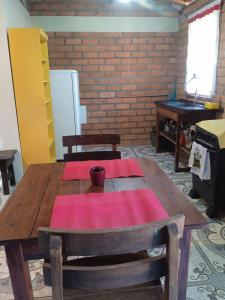 a wooden table with red mats on top of it at Hospedaria das Marias no Vale do Capão in Vale do Capao
