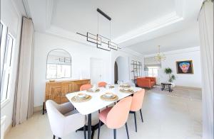 a white dining room with a white table and chairs at Villa Neptune - Private Pool & Game Room in Gammarth
