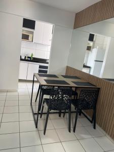 a kitchen with a table and two chairs at Apartamento com 2 quartos de frente para o mar in Maceió