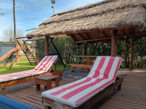 two lounge chairs on a deck with a gazebo at Quinta El Cholito in Luján