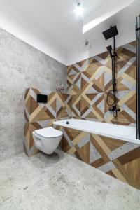 a bathroom with a toilet and a wooden wall at Premium Nakielska 46 przy Parku 40m2 garaż in Bydgoszcz +23 photos