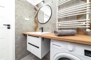 a bathroom with a sink and a washing machine at Premium Nakielska 46 przy Parku 40m2 garaż in Bydgoszcz
