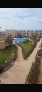 a walkway through a resort with a pool and buildings at Tropical Resort Pool View - Three Bedroom in Santa Maria