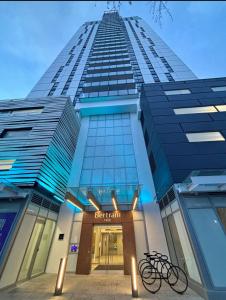 a tall building with a bike parked in front of it at modern private bedroom with private bathroom in a 34-story tower with rooftop lounge in Kelowna