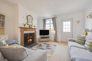 a living room with a fireplace and a tv at Ivy Cottage in Thurgarton