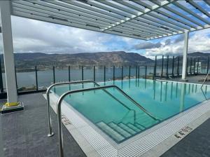 a swimming pool with a view of the water at modern private bedroom with private bathroom in a 34-story tower with rooftop lounge in Kelowna