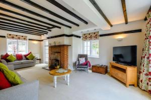 a living room with a fireplace and a television at Rose Cottage - West Runton in West Runton