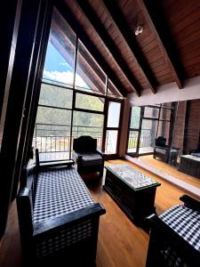 a large room with chairs and a couch and windows at Casa familiar en centro de Quito in Quito