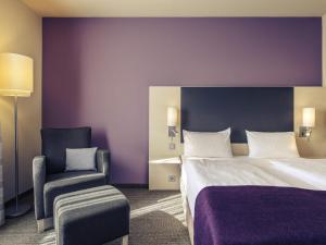 a hotel room with a bed and a chair at Mercure Hotel Berlin City West in Berlin