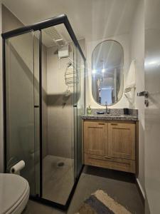ein Badezimmer mit Dusche, Waschbecken und Spiegel in der Unterkunft Apto novo e aconchegante ao lado do Allianz in São Paulo