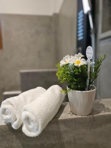 a bathroom counter with towels and a vase of flowers at The Blacksmith Villa in Habaraduwa Central +18 photos