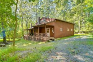 a small house in the middle of a forest at Cabin Comfort Near PSU! Fire Pit and On-Site Trails in Gatesburg