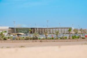 a parking lot with a lot of cars and a building at Aéroport hostel et chambre appartement studio Marrakech in Marrakesh
