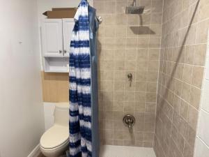 a shower with a blue and white shower curtain in a bathroom at Family home with big backyard in New Port Richey in New Port Richey +10 photos