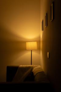 una lampada nell'angolo di una stanza di NivoNest a Gurgaon 1 altra foto