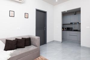un soggiorno con divano e cucina di NivoNest a Gurgaon