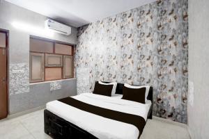 a bedroom with a bed with a floral wallpaper at Super Hotel O The Comfort in Kānpur