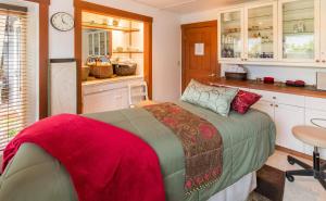 a bedroom with a bed and a kitchen with cabinets at The Heron Inn and Day Spa in La Conner