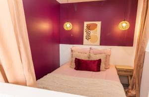 - une petite chambre avec des murs violets et un lit dans l'établissement Siloé - Balnéo - Stationnement gratuit dans la rue- Gare 10 min à pied, à Troyes