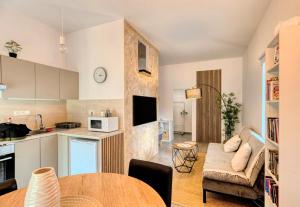 a kitchen and a living room with a table at Jazzy Garden Apartment Komárno in Komárno
