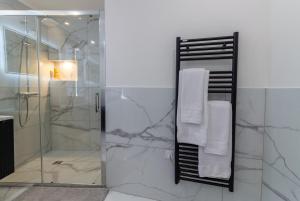 une salle de bain avec douche avec serviettes blanches et miroir dans l'établissement Siloé - Balnéo - Stationnement gratuit dans la rue- Gare 10 min à pied, à Troyes