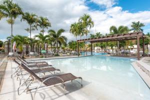 una piscina con tumbonas y palmeras en diRoma Resort direto com o Grupo diRoma com acesso ao Acqua Park e Café da manhã, en Caldas Novas